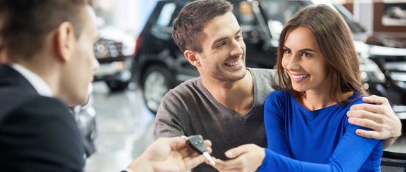 Happy couple receiving their new car keys